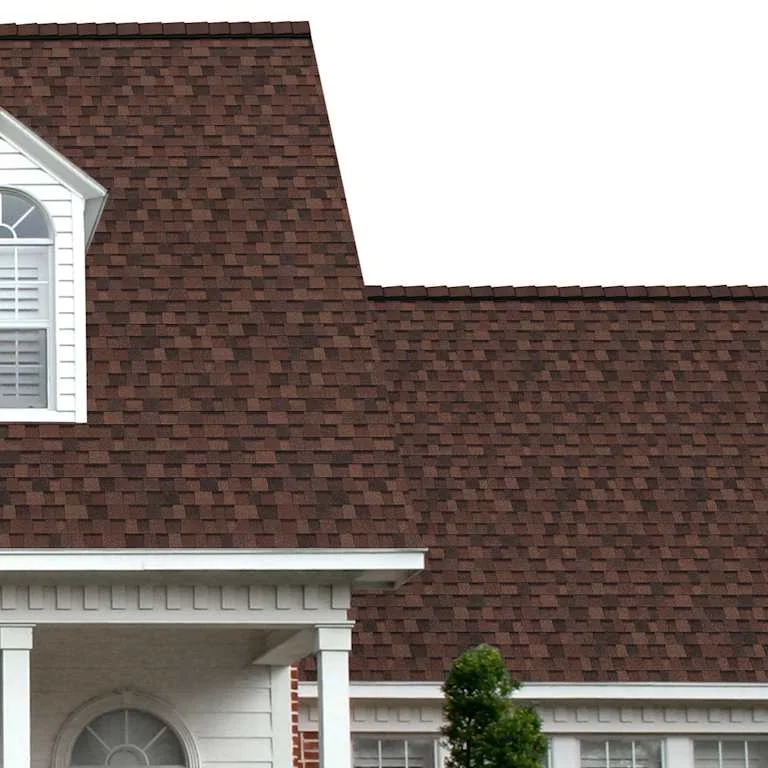 The porch entryway to a home depicts how well Brownwood TruDefinition® Duration® dark brown, light brown, black and golden tan shingles pair with the white horizontal paneling and a woodgrain door with white columns.