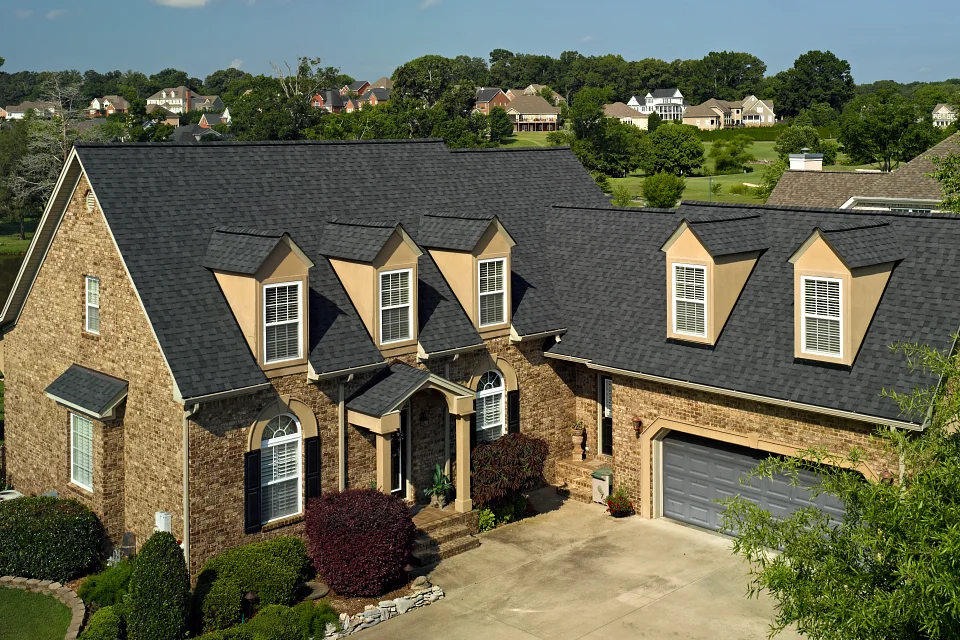 Landmark Pro Max Def Moire Black on a house with stone siding